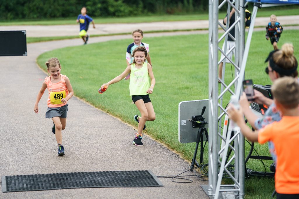 just some kids helping another cross the finish line