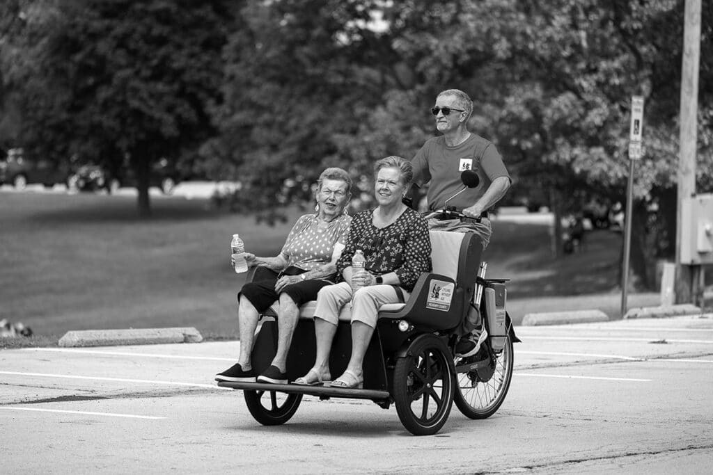 independent photo by andrew rousey
Grace Lutheran Church members Donna Freeman (left) and Denise Klabubde enjoy a trishaw ride in Emricson Park with pilot Mike Phillips.